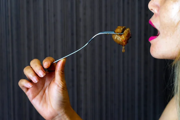 Asian female holding fork eating meatball with sweet chilli sauce — Stock Photo, Image