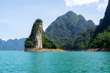 Mavi su üzerinde kireçtaşı dağlarda yeşil orman