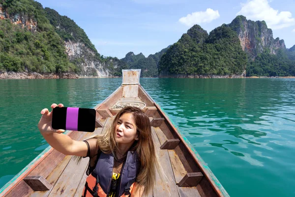 Asiatisk kvinna tar Selfie på träbåt med berg bakgrund — Stockfoto