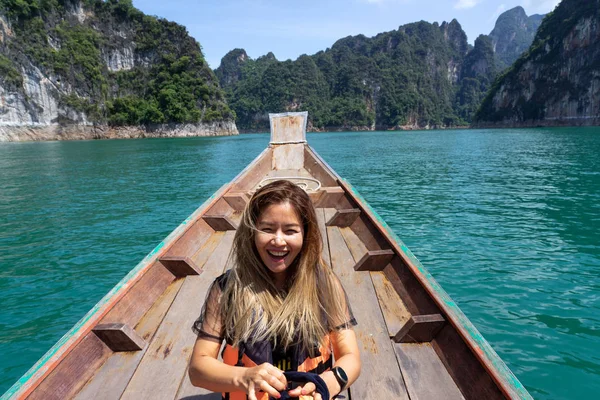 Asiatisk kvinna skrattar på träbåt med kalksten berg bakgrund — Stockfoto