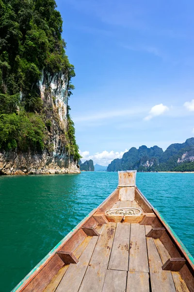 Träbåt på grön sjö med kalkstensberg och klippa — Stockfoto