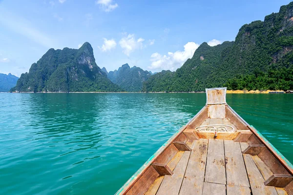 Träbåt i grön sjö med kalksten bergskedjan bakgrund — Stockfoto