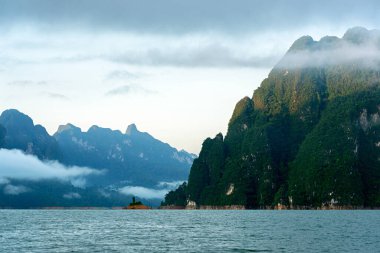 Sabah ışığında yeşil dağ ve Tayland, Surat Thani 'deki Khao Sok Ulusal Parkı' nda mavi göllü sis..