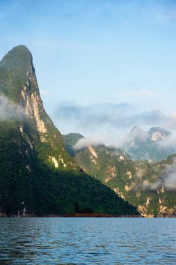 Bulutları, gölü ve mavi gökyüzü olan kireçtaşı sıradağları sabah vakti Surat Thani, Tayland 'daki Khao Sok Ulusal Parkı' nda..