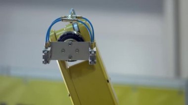 Endüstriyel robot manipülatör sarı renk kontrol ünitesi programlanmış hareketler yapar. Hareket halinde çekim