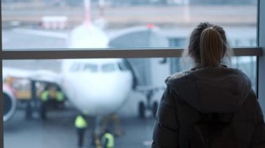 Genç kız ya da gözlük, bir uçak havaalanında, bakarak bir fularlı genç onun pasaport ve bilet tutarak. Geç ve biraz kayıp bir kız. El izleme atış.