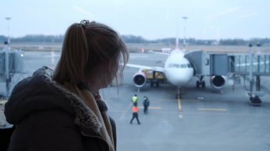 Genç kız ya da gözlük, bir uçak havaalanında, bakarak bir fularlı genç onun pasaport ve bilet tutarak. Geç ve biraz kayıp bir kız. El izleme atış.