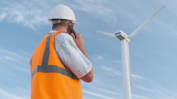 Ingeniero Masculino Proyecta Trabajo Cerca Turbina Eólica Hace Una Llamada — Vídeos de Stock
