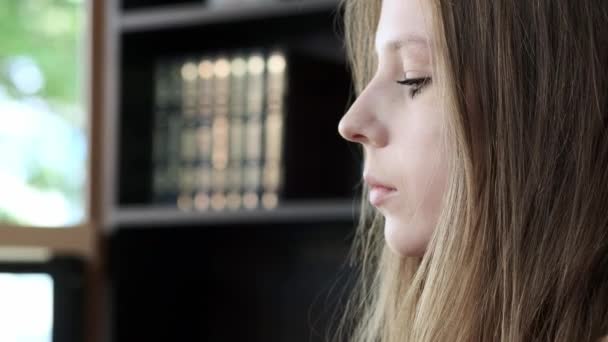 Uma jovem menina bonita em um café elegante bebe café na parte da manhã antes do trabalho. Senta-se em frente à janela. Ele bebe café de um copo preto de papelão. Close-up . — Vídeo de Stock