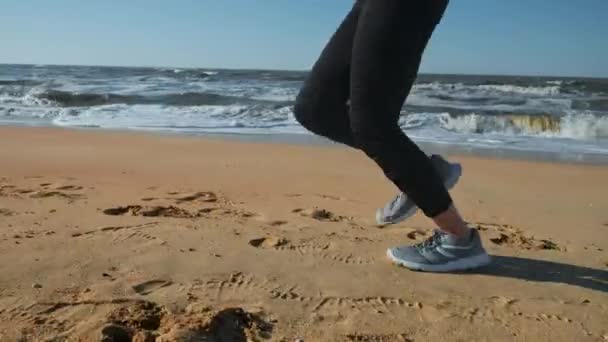 20'li yaşlarda batımında sahilde kum üzerinde çalışan kız. Açık havada koşu. — Stok video