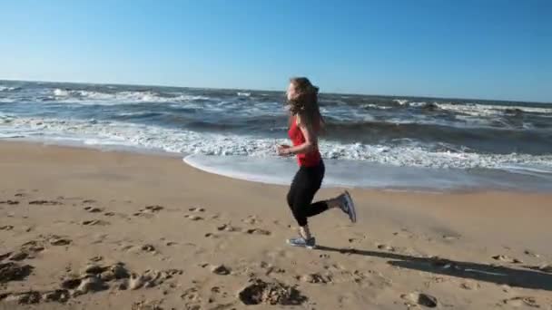 Chica de 20 años corriendo en la arena en la playa al atardecer. Correr al aire libre . — Vídeos de Stock