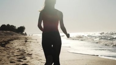 Genç bir kız plajda kırmızı spor içinde çalışır. Kulaklıklar müzik dinler. Bir akşam ya da sabah dürtmek günbatımı ya da şafak gerçekleştirir.