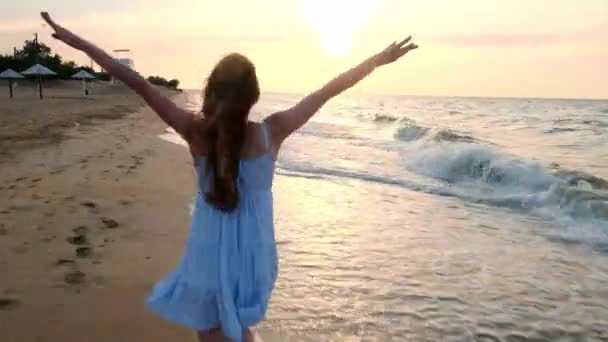 MOCIÓN LENTA: Chica corriendo en aguas poco profundas al atardecer. Una chica vestida de blanco corre por el borde del mar. Estoy feliz con el mar y la playa. Experimentar la libertad . — Vídeos de Stock