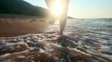 Kız su kenarı yürüyüş. Kıyı kum üzerinde kadın. Kamera sonra erkek hareket ediyor.