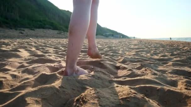 Kobieta spaceru nad mokrym piasku na plaży. Kobiece stopy krok na żółty piasek z muszelek. Szczęście i wolność. — Wideo stockowe