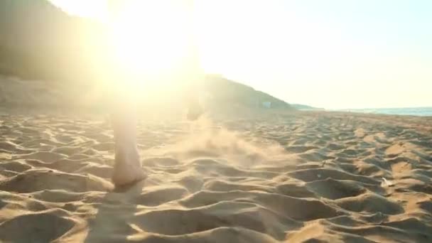 Γυναίκα που περπατά πάνω από την υγρή άμμο στην παραλία. Γυναικεία πόδια βήμα στην κίτρινη άμμο από κοχύλια. Την ευτυχία και την ελευθερία. — Αρχείο Βίντεο