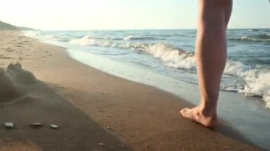 Kız su kenarı yürüyüş. Kıyı kum üzerinde kadın. Kamera sonra erkek hareket ediyor.