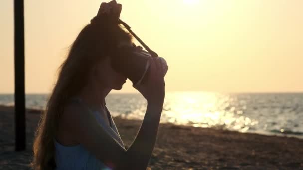 Fiatal nő használ egy virtuális valóság szemüveg a strandon. Szexi lány kezd tapasztalattal rendelkezik a Vr-headset nyári tengeri háttér.