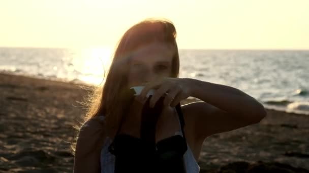 Jonge vrouw maakt gebruik van een virtual reality bril op het strand. Sexy meisje krijgt ervaring in het gebruik van Vr-headset op zomer op zee achtergrond. — Stockvideo