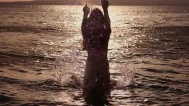 seksi kız su sıçramalarına yapıyor. Denizde dinlenme ve tatil ve özgürlük ile memnun eder. Arkadaş grubu keşfetmek