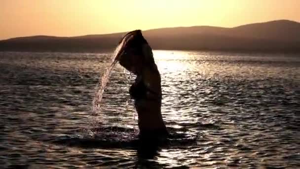 Chica sexy haciendo salpicaduras en el agua. Agradece el descanso y las vacaciones y la libertad en el mar. Explorando con amigos . — Vídeo de stock