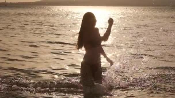 Seksi kız su sıçramalarına yapıyor. Denizde dinlenme ve tatil ve özgürlük ile memnun eder. Arkadaş grubu keşfetmek. — Stok video