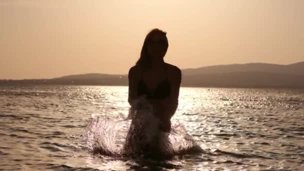 Chica sexy haciendo salpicaduras en el agua. Agradece el descanso y las vacaciones y la libertad en el mar. Explorando con amigos . — Vídeos de Stock