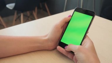 Bir smartphone bir yeşil ekran yeşil ekran, beyaz zemin üzerine, yeni teknoloji kavramı chroma anahtar yeşil ekran ile mobil akıllı telefon tutan adamın elini elinde tutan güzel kız
