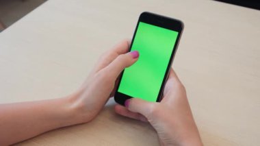 Bir smartphone bir yeşil ekran yeşil ekran, beyaz zemin üzerine, yeni teknoloji kavramı chroma anahtar yeşil ekran ile mobil akıllı telefon tutan adamın elini elinde tutan güzel kız