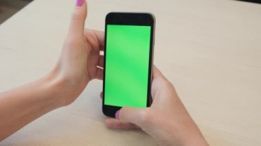 Bir smartphone bir yeşil ekran yeşil ekran, beyaz zemin üzerine, yeni teknoloji kavramı chroma anahtar yeşil ekran ile mobil akıllı telefon tutan adamın elini elinde tutan güzel kız
