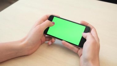 Bir smartphone bir yeşil ekran yeşil ekran, beyaz zemin üzerine, yeni teknoloji kavramı chroma anahtar yeşil ekran ile mobil akıllı telefon tutan adamın elini elinde tutan güzel kız