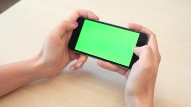 Bir smartphone bir yeşil ekran yeşil ekran, beyaz zemin üzerine, yeni teknoloji kavramı chroma anahtar yeşil ekran ile mobil akıllı telefon tutan adamın elini elinde tutan güzel kız