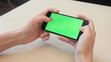 Bir smartphone bir yeşil ekran yeşil ekran, beyaz zemin üzerine, yeni teknoloji kavramı chroma anahtar yeşil ekran ile mobil akıllı telefon tutan adamın elini elinde tutan güzel kız