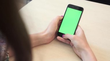 Bir smartphone bir yeşil ekran yeşil ekran, beyaz zemin üzerine, yeni teknoloji kavramı chroma anahtar yeşil ekran ile mobil akıllı telefon tutan adamın elini elinde tutan güzel kız