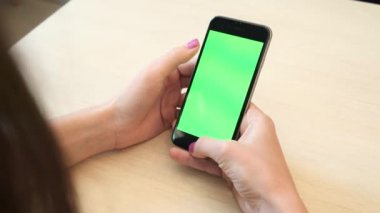 Bir smartphone bir yeşil ekran yeşil ekran, beyaz zemin üzerine, yeni teknoloji kavramı chroma anahtar yeşil ekran ile mobil akıllı telefon tutan adamın elini elinde tutan güzel kız