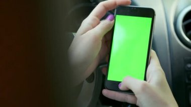 Kız sürücü closeup, arabada, kentsel şehir arka plan yeşil ekran krom anahtar 4k yeşil ekran. Soldaki ekran boyunca elini temizleyicileri.