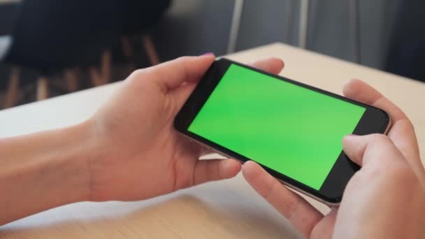 美丽的女孩的绿色绿色屏幕，在白色的背景下，新技术的概念持有与色度键绿屏智能手机的男人的手，手里拿着一部智能手机 — 图库视频影像