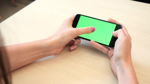 Menina bonita segurando um smartphone nas mãos de uma tela verde tela verde, mão de homem segurando telefone inteligente móvel com tela verde chave chroma no fundo branco, novo conceito de tecnologia — Vídeo de Stock