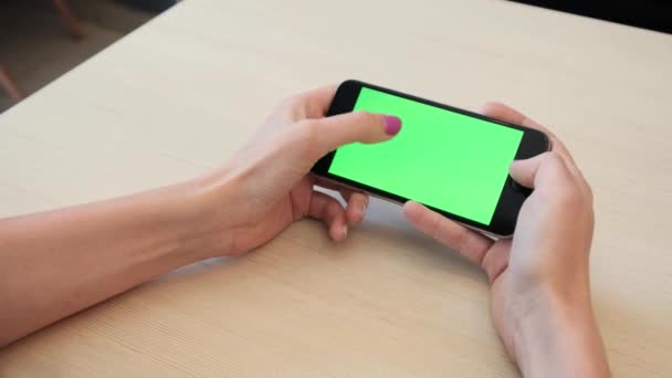 Красивая девушка, держащая смартфон в руках зеленого экрана, рука человека, держащего мобильный смартфон с хрома зеленый экран на белом фоне, новая концепция технологии — стоковое видео