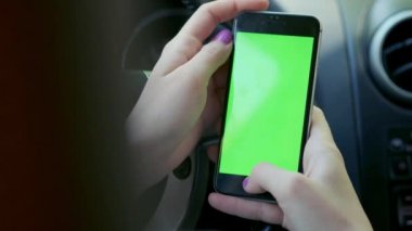 Kız sürücü closeup, arabada, kentsel şehir arka plan yeşil ekran krom anahtar 4k yeşil ekran. Sağdaki ekran boyunca elini temizleyicileri.