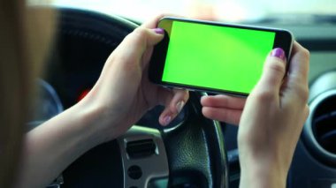 Kız sürücü closeup, arabada, kentsel şehir arka plan yeşil ekran krom anahtar 4k yeşil ekran. Soldaki ekran boyunca elini temizleyicileri.