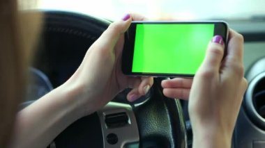 Kız sürücü closeup, arabada, kentsel şehir arka plan yeşil ekran krom anahtar 4k yeşil ekran. Elini yukarı için ekran boyunca temizleyicileri.