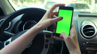 Kız sürücü closeup, arabada, kentsel şehir arka plan yeşil ekran krom anahtar 4k yeşil ekran. Soldaki ekran boyunca elini temizleyicileri.