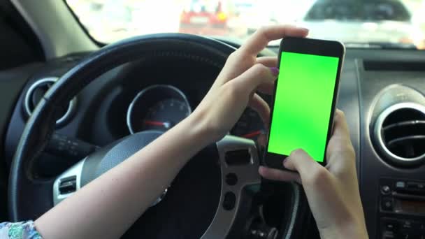 Дівчина драйвер крупним планом, зелений екран в машині, міський фон міста зелений хром ключ 4k. Розтягує руку по екрану праворуч . — стокове відео