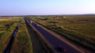 4k Hava: Konteyner yarı kamyon mal meşgul karayolu üzerinde ülke genelinde güzel yaz akşamında taşıma yukarıda yüksekten uçuyor. Sürüş ve altın günbatımında meşgul otobanda hız Rating