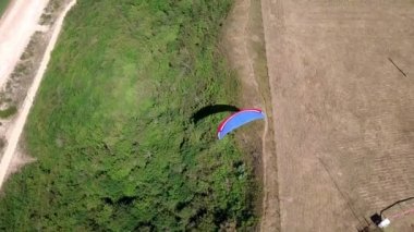 Havadan görünümü. Yamaçparaşütü kıyı şeridi uçar. Yamaçparaşütü kanat rüzgar tarafından üflenir. Satır deniz ve orman.