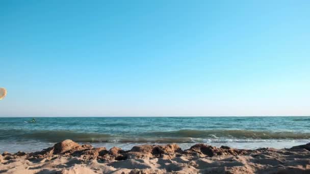 Piękna szczupła dziewczyna spaceru na plaży, trzymając deskę surfingową. Za jej zabawny facet jest chodzenie. Uruchomiona w godzinach wieczornych podczas zachodu słońca. Śmieszne wideo. — Wideo stockowe