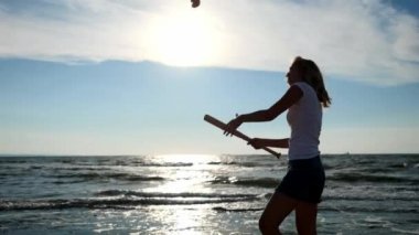 ağır çekim: genç seksi kız yener bir beysbol sopası ile domates meyve ve sebze. Bu plaj, kumlu plaj üzerinde yer almaktadır.