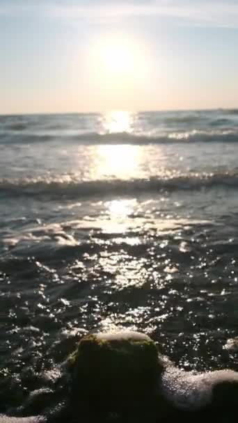 Морские волны брызгают на задний камень. Волны воды брызгают вокруг камня, выступающего из моря. Закрыть морские волны воды на фоне камня — стоковое видео
