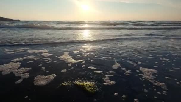 Mořské vlny stříkající na pozadí kamene. Vlny voda cáká kámen vyčnívající z moře. Detailní záběr mořské vlny vody na pozadí kámen — Stock video